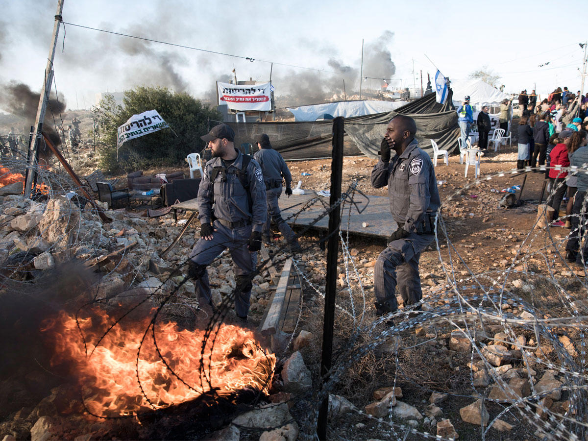 جنود إسرائيليون خلال إخلاء مستوطنة  غير شرعية قرب الخليل أمس (أي بي ايه)
