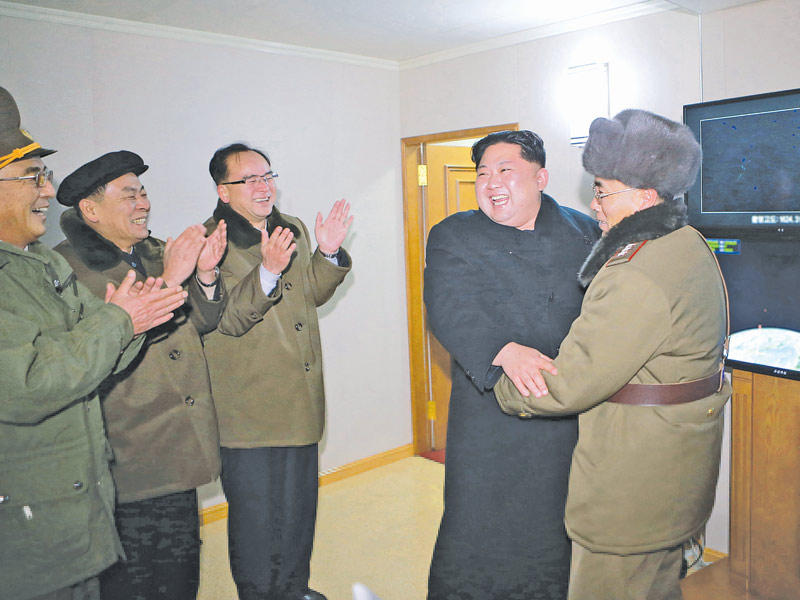 زعيم كوريا الشمالية كيم جونغ اون معانقاً قادته العسكريين بعد التجربة الصاروخية الأخيرة (رويترز)