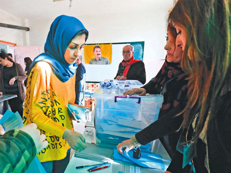 كردية تدلي بصوتها في انتخابات روج آفا في القامشلي أمس (أ ف ب)