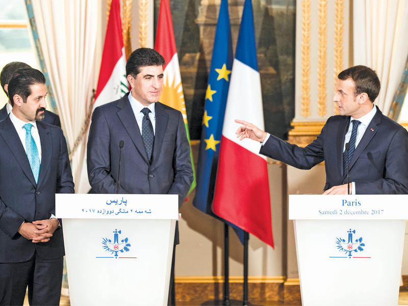 ماكرون خلال المؤتمر الصحافي المشترك مع البارزاني ونائبه قباد الطالباني في قصر الإليزيه بباريس أمس (رويترز)