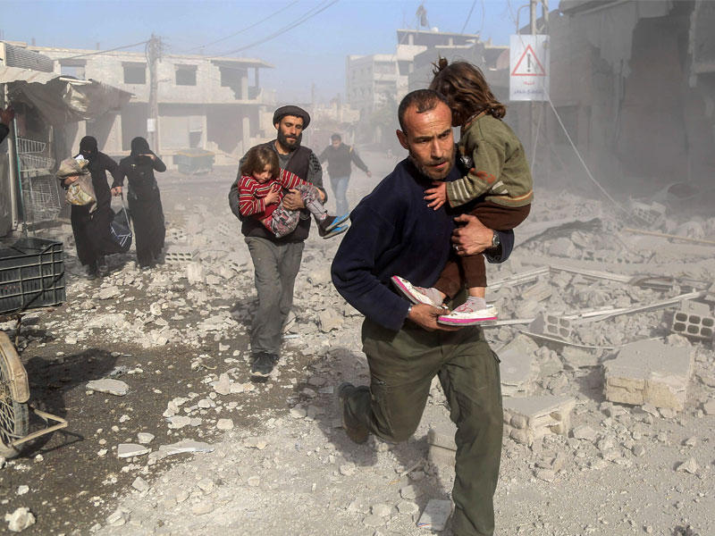 سوريون في موقع تعرض لغارة في بيت سوا شرق الغوطة أمس (أ ف ب)