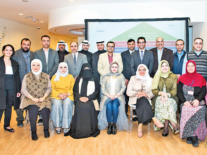 مدير مستشفى بنك الكويت الوطني التخصصي للأطفال ونائبه مع العاملين بالمستشفىn