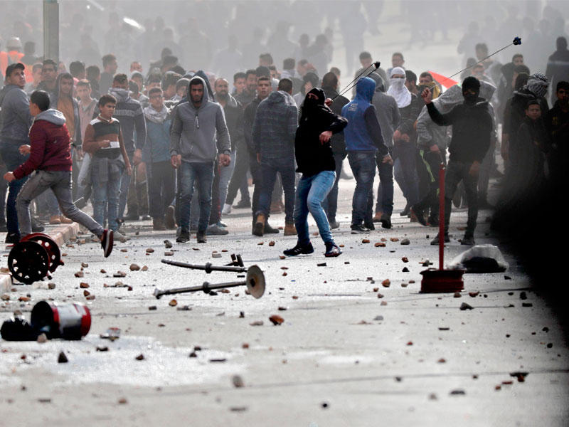 فلسطينيون خلال مواجهات مع الجيش الإسرائيلي غرب الضفة الغربية أمس (أ ف ب)