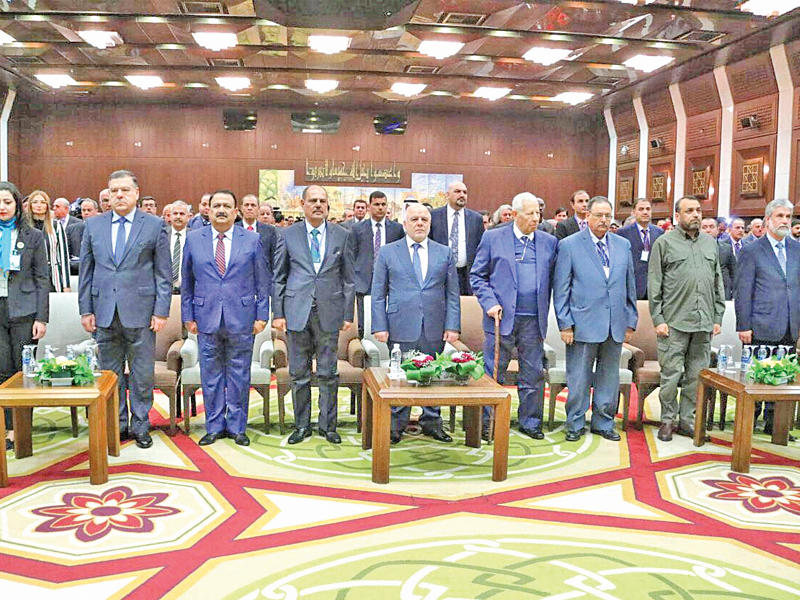 العبادي متوسطا الحضور خلال مشاركته بـ«مؤتمر الإعلام» في بغداد أمس (رويترز)