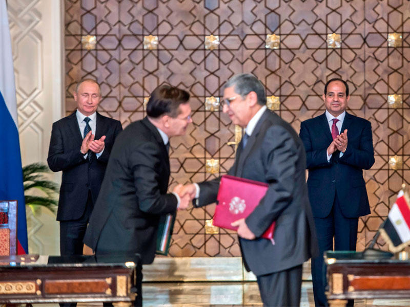 وزيرا الطاقة المصري والروسي يتبادلان العقود الموقعة بحضور السيسي وبوتين في القاهرة أمس (أ ف ب)