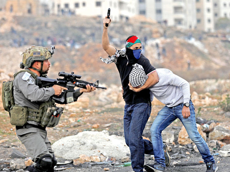 أحد المستعربين لحظة اعتدائه على فلسطيني قرب رام الله (رويترز)