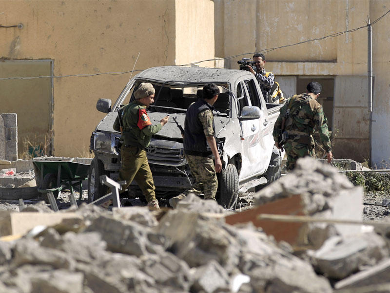 مسلحون حوثيون داخل الموقع الذي استهدفته مقاتلات «التحالف» في صنعاء أمس (أ ف ب)