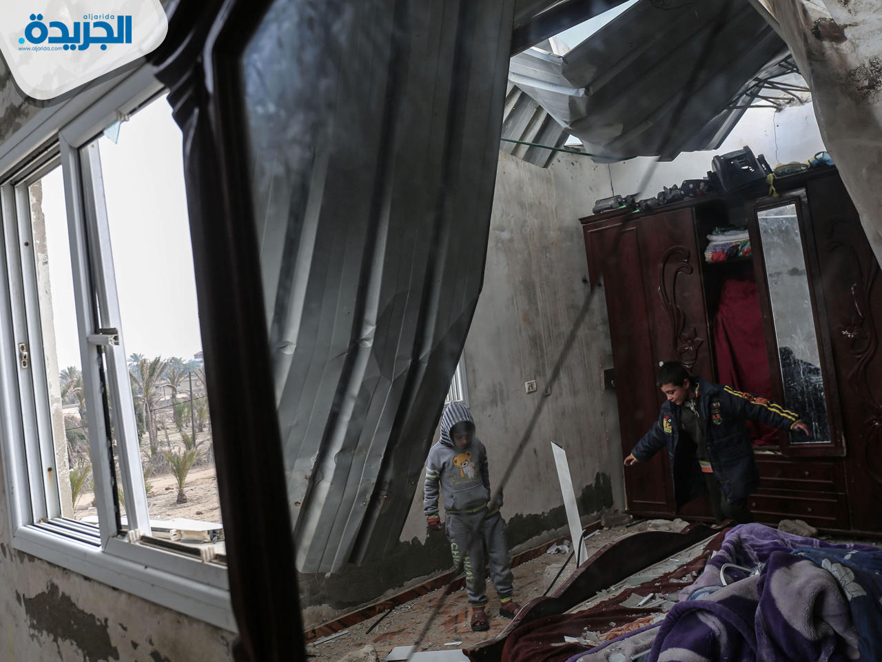 أطفال يتفقدون منزلهم الذي أصيب بأضرار في غارة جوية إسرائيلية في خان يونس جنوب قطاع غزة
