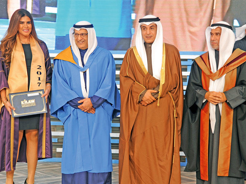 الوزير العازمي مكرما إحدى خريجات كلية القانون 