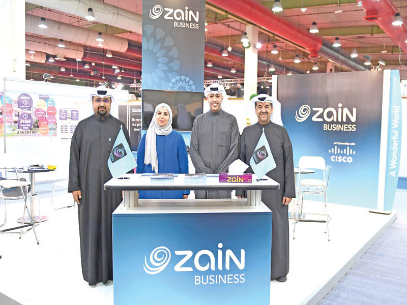 الفارس مع مسؤولي زين في جناح الشركة بالمعرض