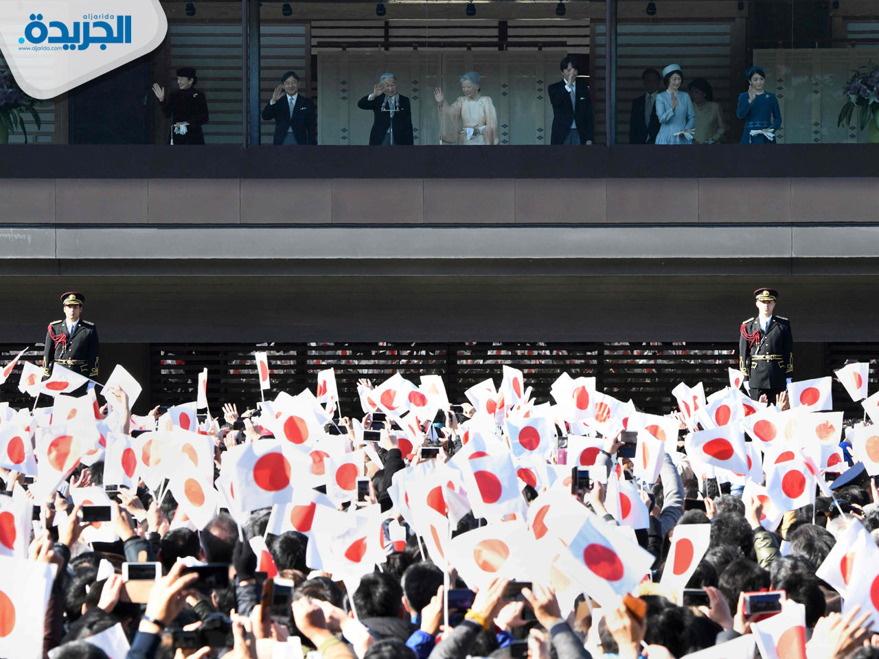 امبراطور اليابان ملوحاً للمتجمعين أمام قصره
