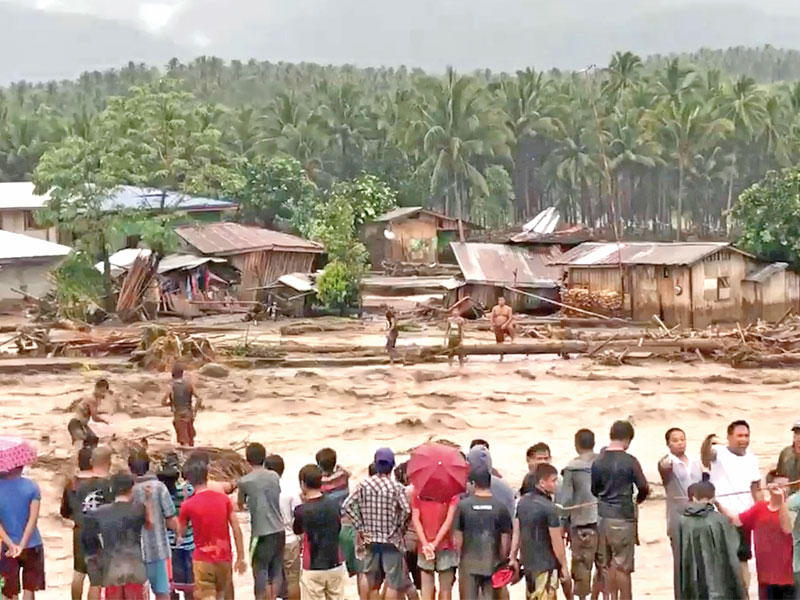 سكان منطقة لاناو ديل نورت يحاولون إنقاذ عالقين بمياه الأمطار والفيضانات الجمعة الماضية (رويترز)