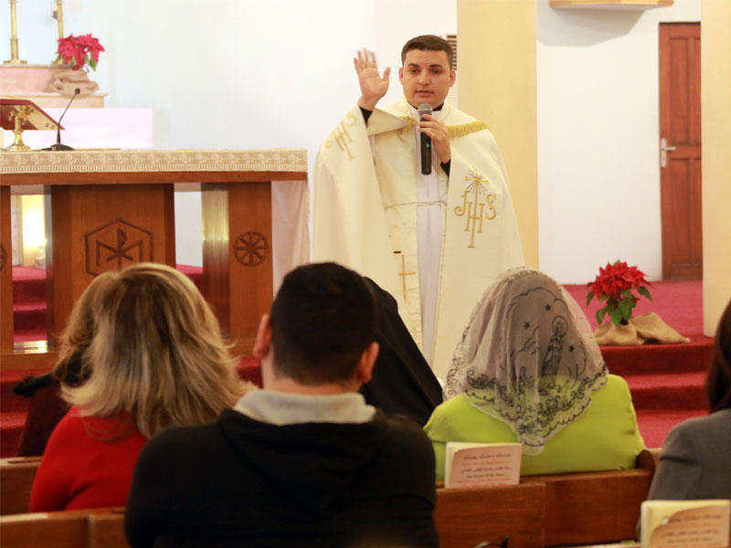 الكاهن مارتن باني يقود الصلاة خلال عيد الميلاد في كنيسة مريم العذراء في حي الكرادة بغداد