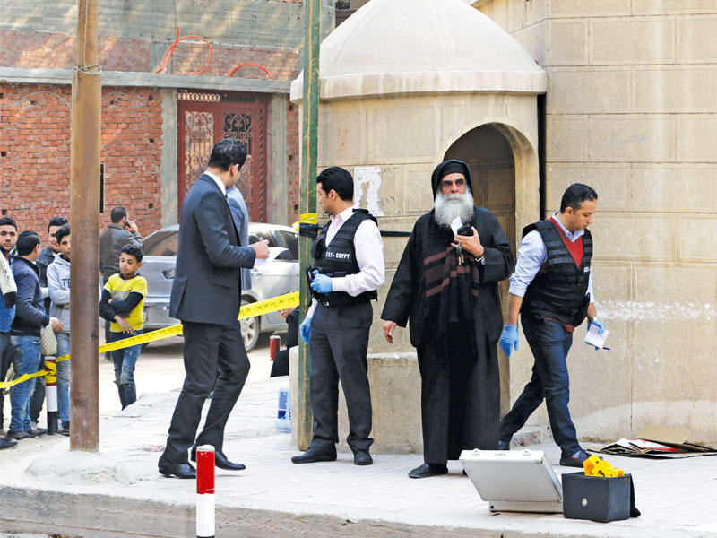 رجل دين مسيحي وسط عناصر امنية في موقع الهجوم قرب الكنيسة (أي بي أيه) 