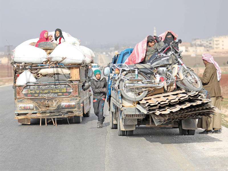 عائلة سورية مهجّرة من إدلب تنقل أمتعتها على أوتوستراد دمشق - حلب  أمس (أ ف ب)