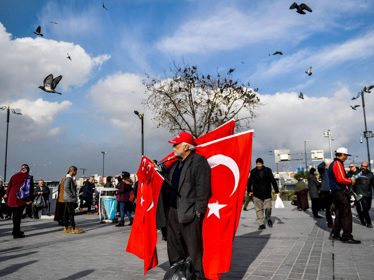 رجل يبيع أعلام تركيا في ساحة امينونو في الجزء الأوروبي من إسطنبول أمس  (أ ف ب)