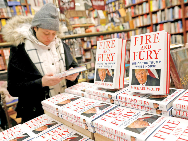 سيدة تطالع  نسخة من كتاب «نار وغضب» في إحدى مكتبات نيويورك	(رويترز) 