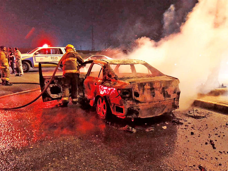 رجال الإطفاء يكافحون حريق المركبة