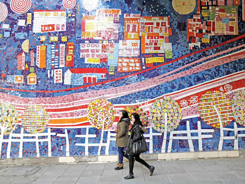 إيرانيتان تمران أمام جدارية في طهران أمس (أ ف ب)