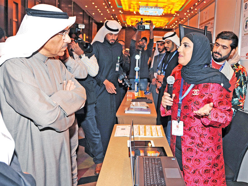 الوقيان يستمع لشرح مشروع إحدى الطالبات في المعرض (تصوير عوض التعمري)