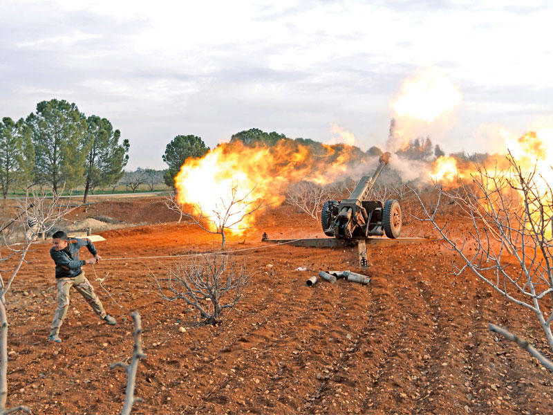 مقاتل معارض يقصف مواقع النظام في إدلب بمدفع أمس الأول  (أ ف ب)