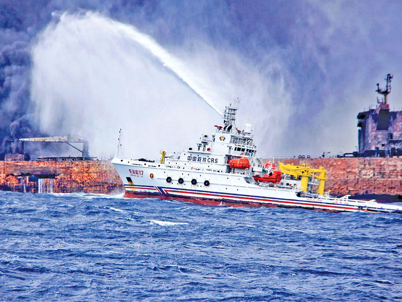 فرقاطة تحاول إخماد حريق ناقلة النفط الإيرانية قبالة ساحل الصين أمس (أ ف ب)n