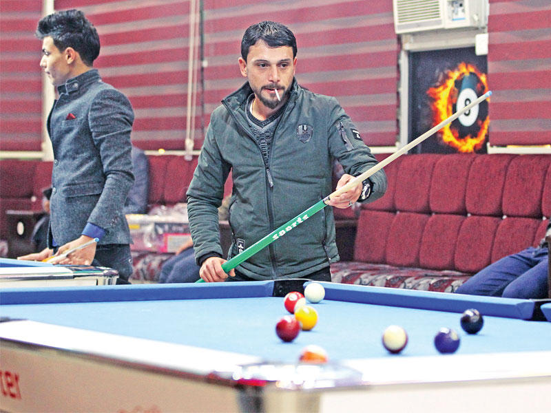 عراقيون يلعبون البلياردو في مقهى على ضفة الموصل الشرقية أمس الأول (أ ف ب)