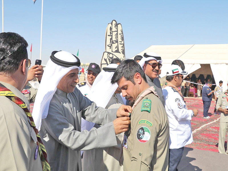 العازمي مكرما أحد الكشافة خلال افتتاح المخيم أمس