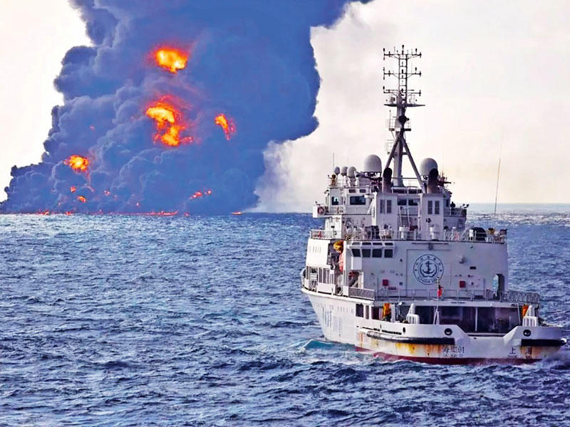 فرقاطة صينية بالقرب من ناقلة نفط إيرانية تلتهمها النيران قبل غرقها في المياه الصينية أمس (أ ف ب)
