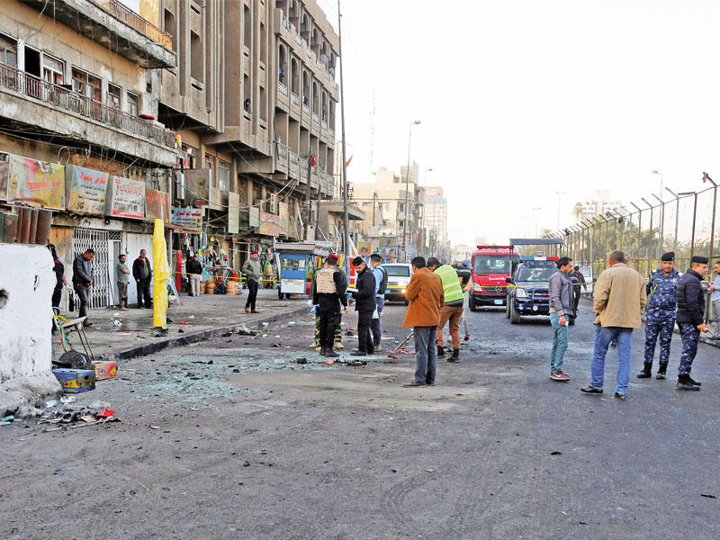 رجال من الشرطة والدفاع المدني يتفقدون مكان التفجير في ساحة الطيران في بغداد أمس (رويترز)