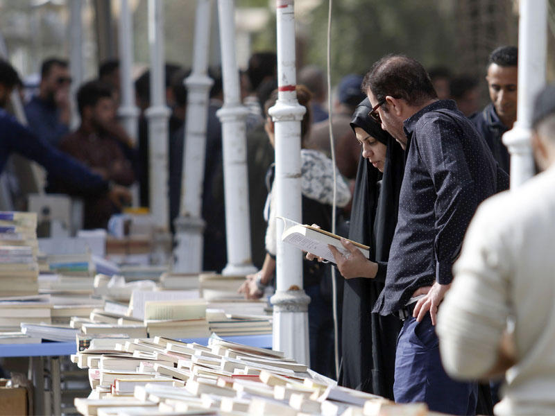 عراقيون في سوق كتب بشارع الفراهيدي في البصرة أمسt(أ ف ب)