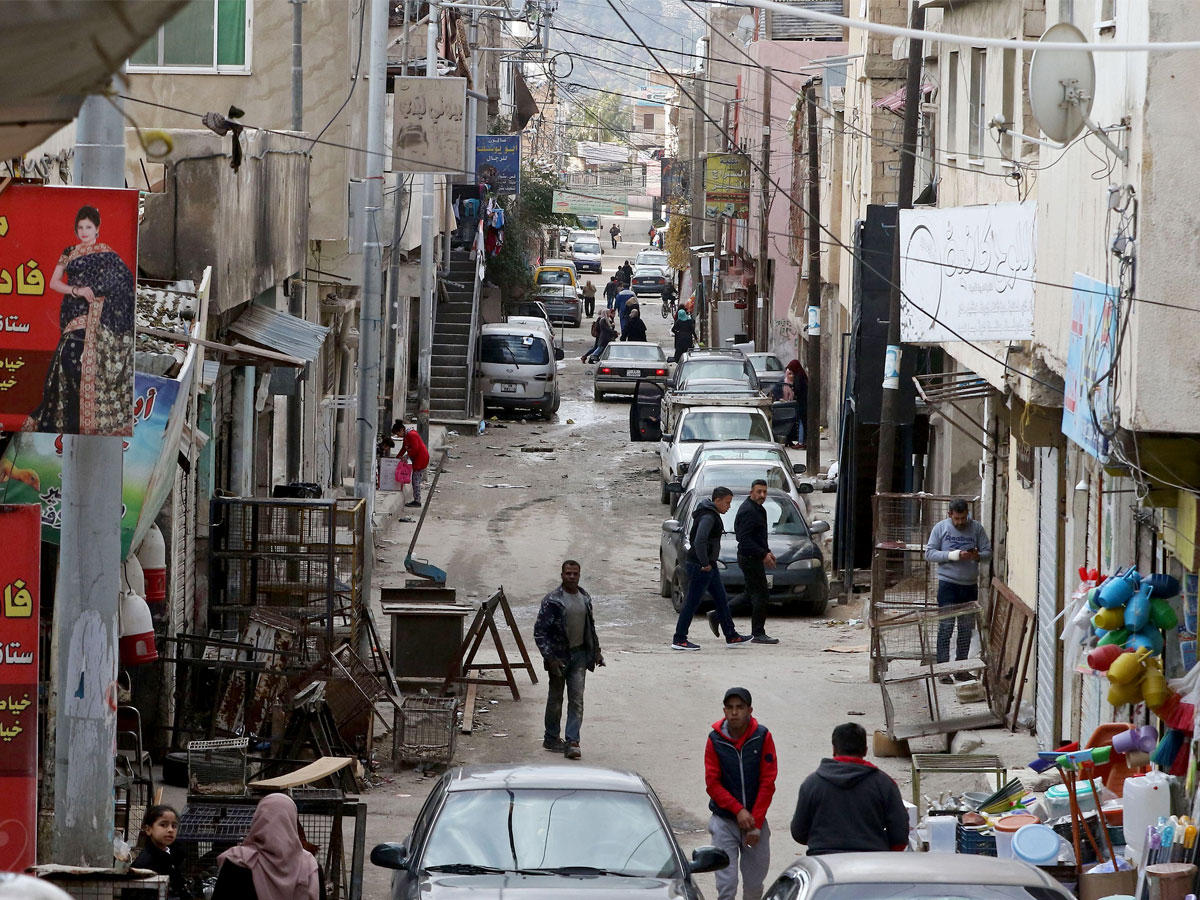 فلسطينيون في أحد أحياء مخيم البقعة للاجئين في شمال عمان (أ ف ب)