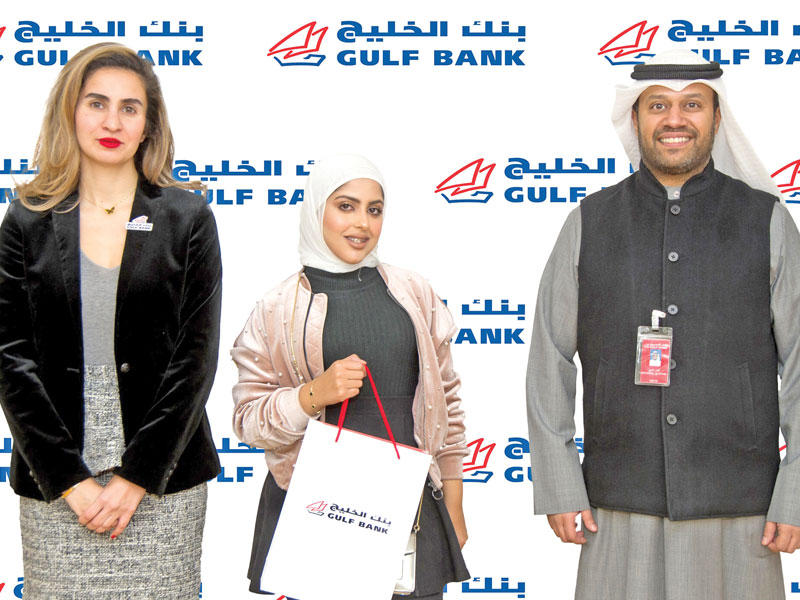 منال بركات ومحمد العتيبي من بنك الخليج مع إحدى الفائزات