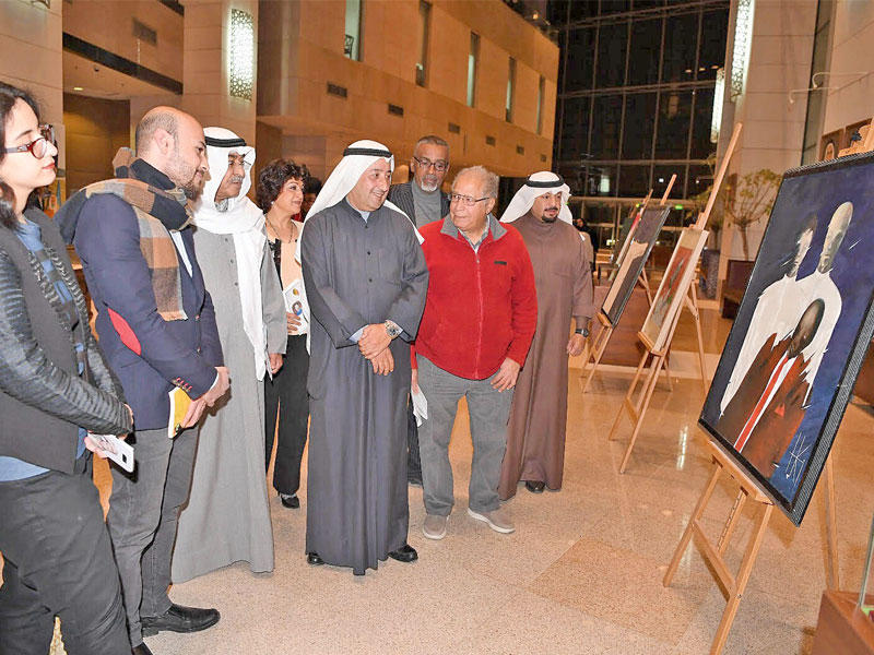 محمد العسعوسي وعدد من الفنانين أثناء الجولة في المعرض 