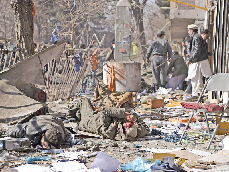 مسعفون ينتشلون جثث ضحايا انفجار سيارة الإسعاف المفخخة في كابول أمس (أ ف ب)