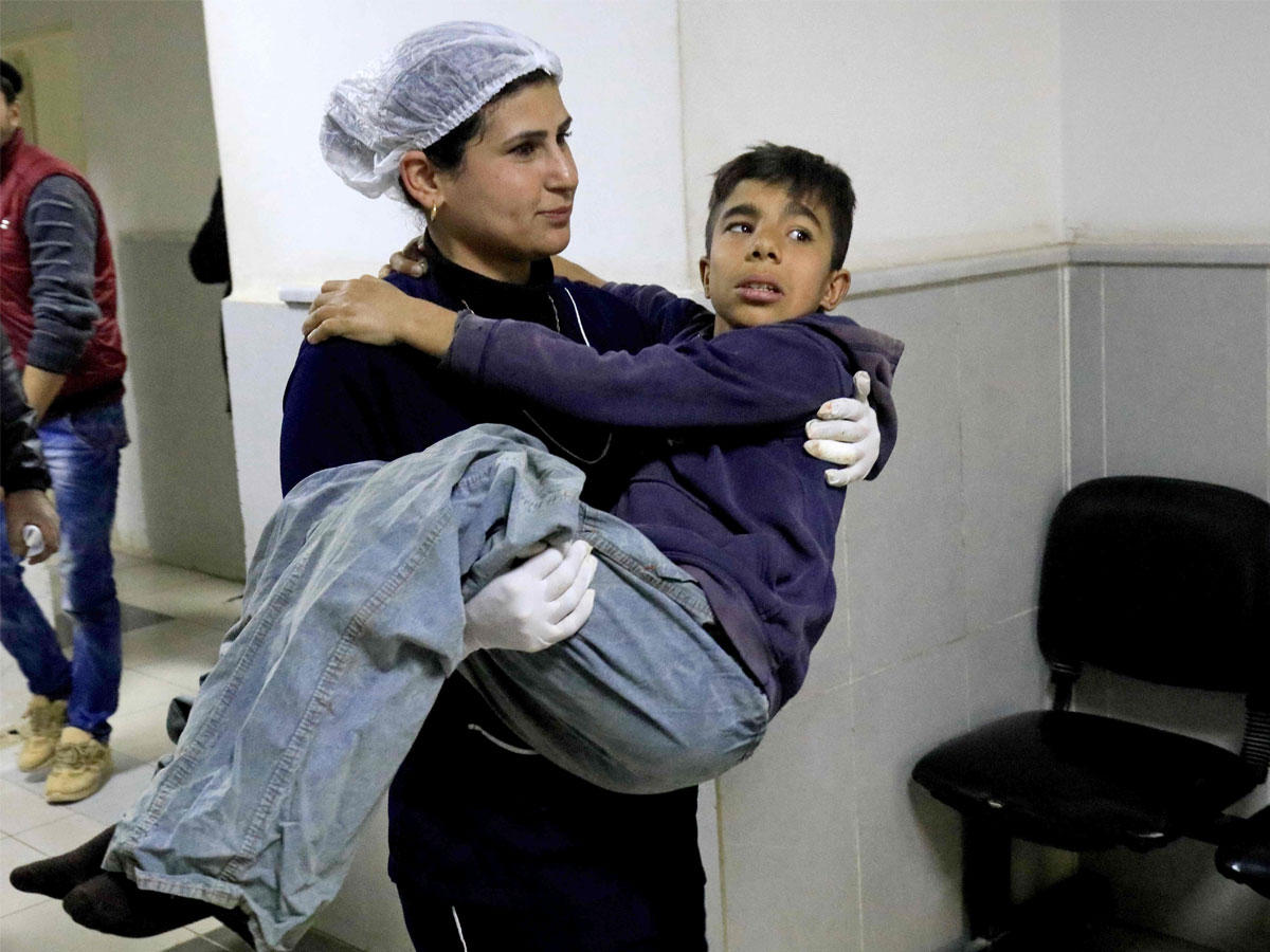 ممرضة كردية تنقل صبياً لإسعافه في مستشفى عفرين أمسt(أ ف ب)