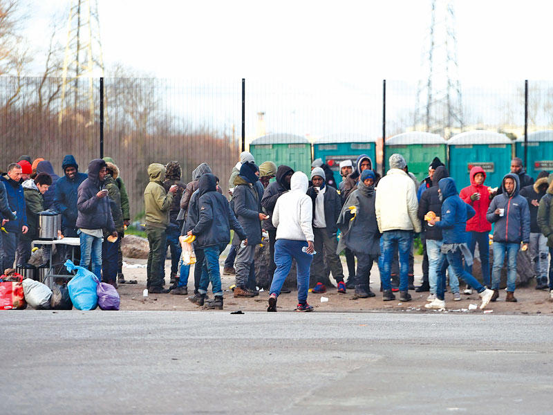 مهاجرون في منطقة كاليه أمس بعد المواحهات الليلية  (ا ف ب)