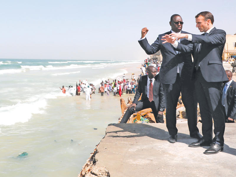 الرئيس السنغالي ماكي سال مصطحباً نظيره الفرنسي إيمانويل ماكرون بجولة على الواجهة البحرية لسانت لويس أمس (أ ف ب)