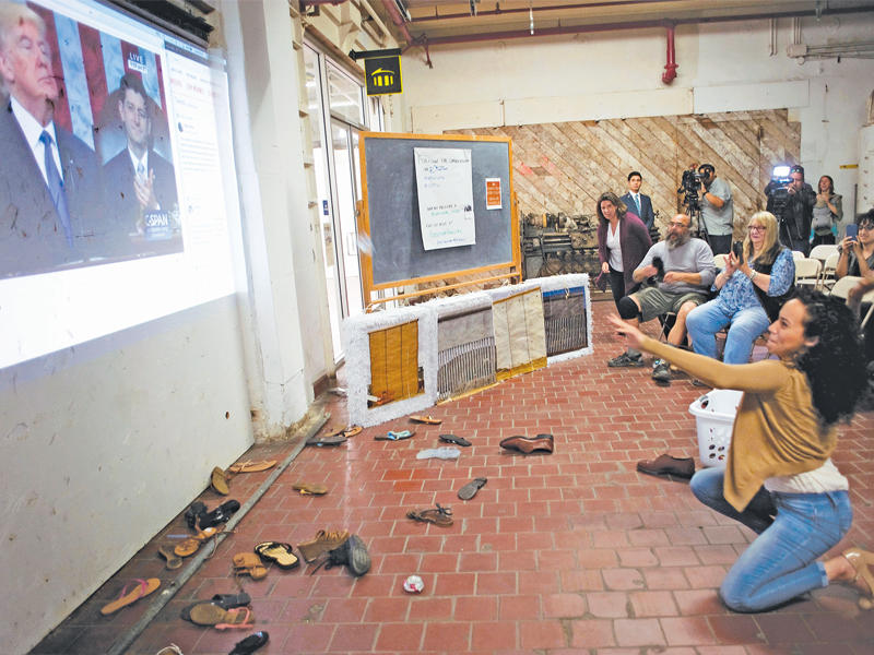أميركيون يرشقون بأحذيتهم شاشة يظهر عليها ترامب ملقياً خطاب حال الاتحاد الثلاثاء الماضي (اي بي أيه)