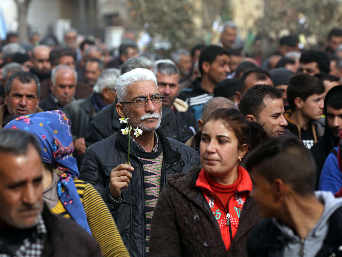 رجل يحمل كردي سوري زهرة أثناء مسيراته في مدينة عفرين السورية تدين العملية العسكرية التي يقوم بها الجيش التركي