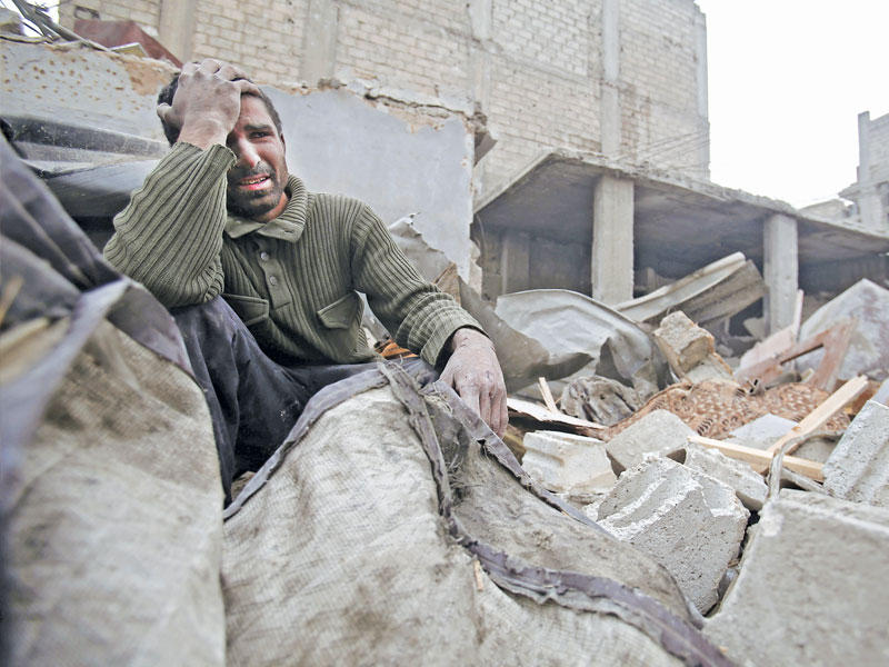 سوري وسط الركام بعد الغارات على الغوطة أمس (أ ف ب)