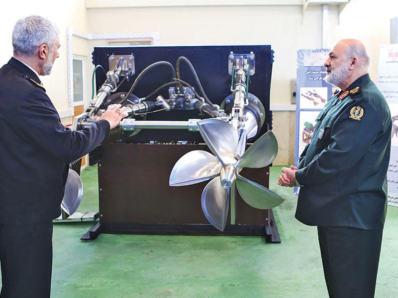 مساعد وزير الدفاع الإيراني يكشف الستار عن محرك طورته بحرية بلاده في طهران أمس (إرنا)