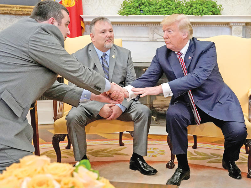 ترامب مصافحاً شاين بوفيه خلال استقباله له ولوالده دونالد أمس الأول في البيت الأبيض بعد منحهما 10 آلاف دولار لعلاج والده من مرض السرطان      (رويترز)