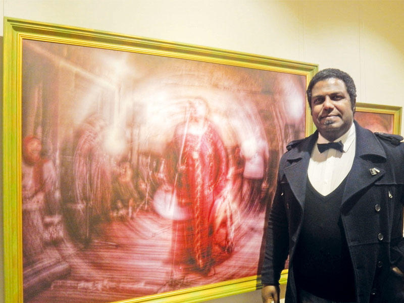 خالد ابو الدهب إلى جانب أحد  أعمالهn