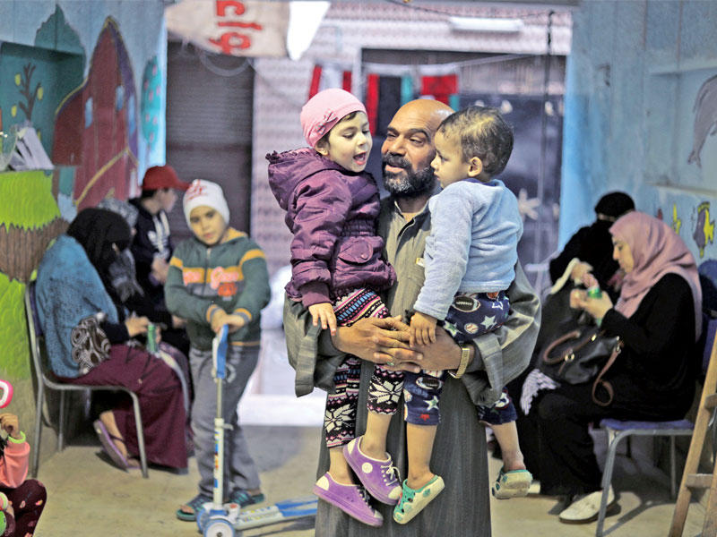 مصري يحمل طفلين أمس داخل مقر خصصه لاستقبال أسر أطفال يعالجون من السرطان بمستشفى «57357» لتخفيف الأعباء عن أهالي المحافظات البعيدة عن القاهرة.ويتيح الرجل وهو جزار أطلق عليه «بابا ظاظا» لأسر الأطفال الإقامة مجاناً في المقر المجاور للمستشفى الكائن بحي السيدة زينب مادام أطفالهم يتلقون علاجاً بالمستشفى، ولا يشترط عليهم سوى تقديم شهادة طبية من المستشفى وبطاقة الهوية.tttttt        (رويترز)