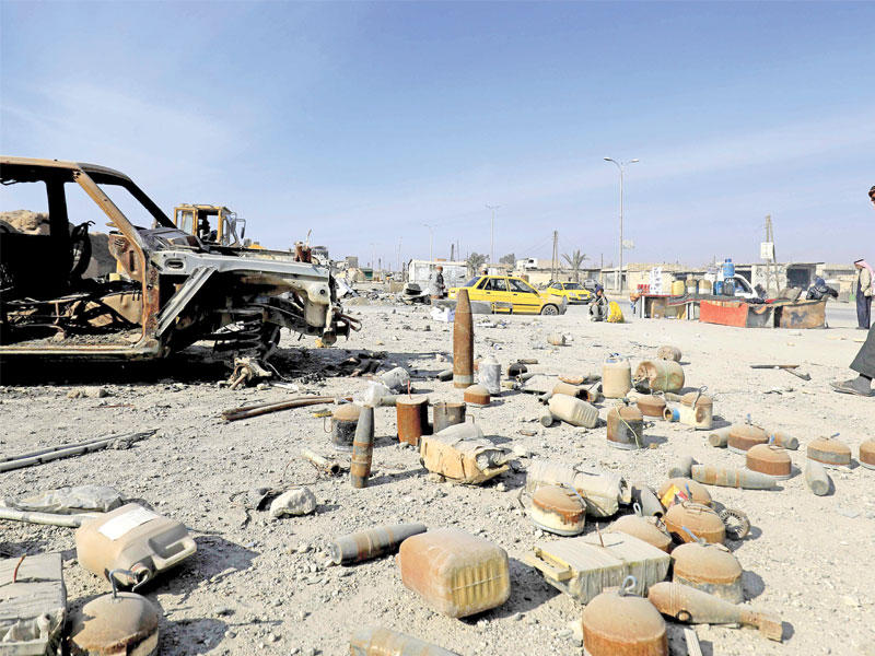 سوري يمر أمس بمنطقة مخلفات ألغام تركها «داعش» في الرقة (أ ف ب)