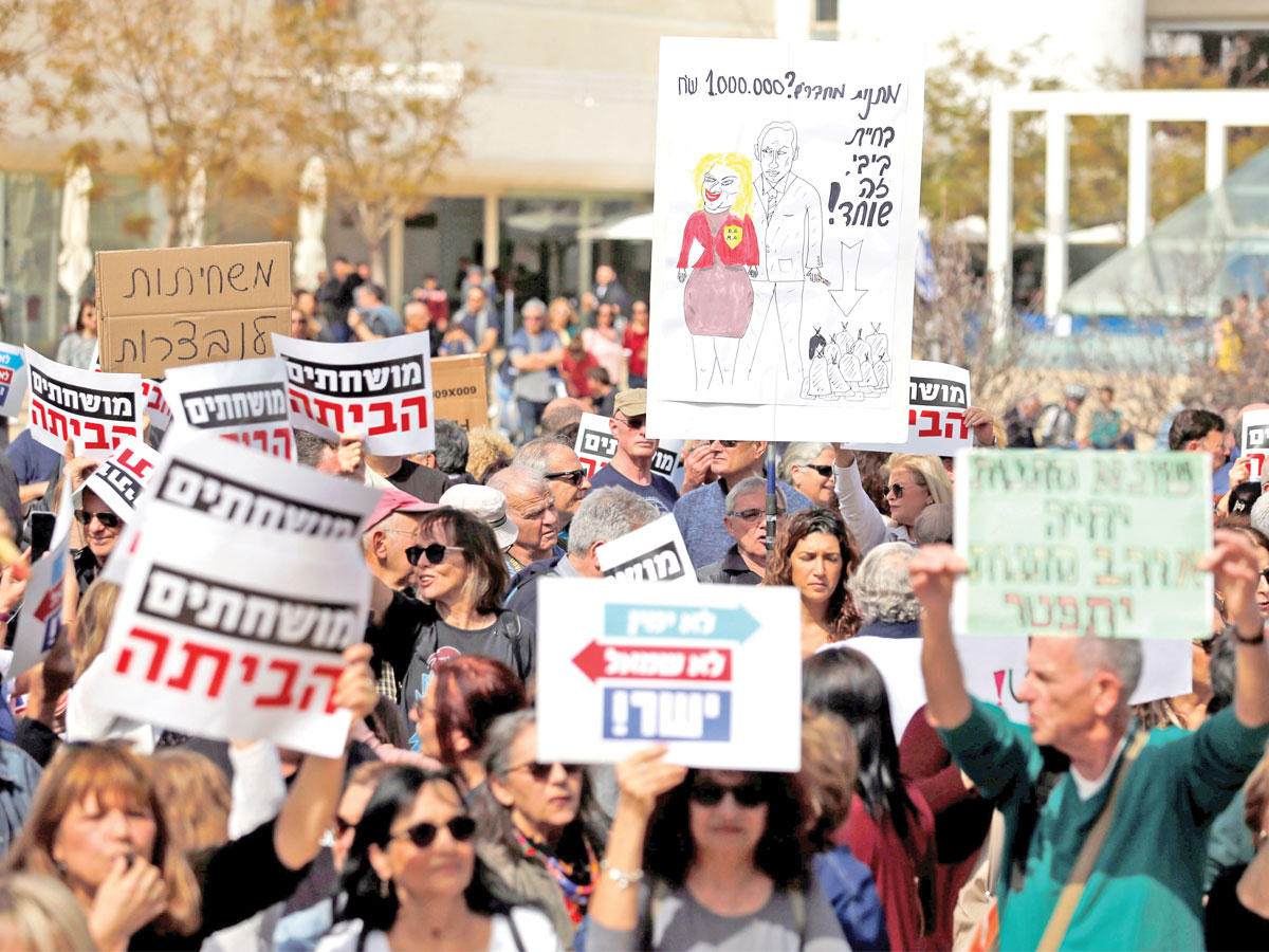 إسرائيليون يرفعون صوراً ولافتات تتهم نتنياهو بتلقي رشاوى وتطالبه بالاستقالة في تل أبيب أمس  (رويترز)