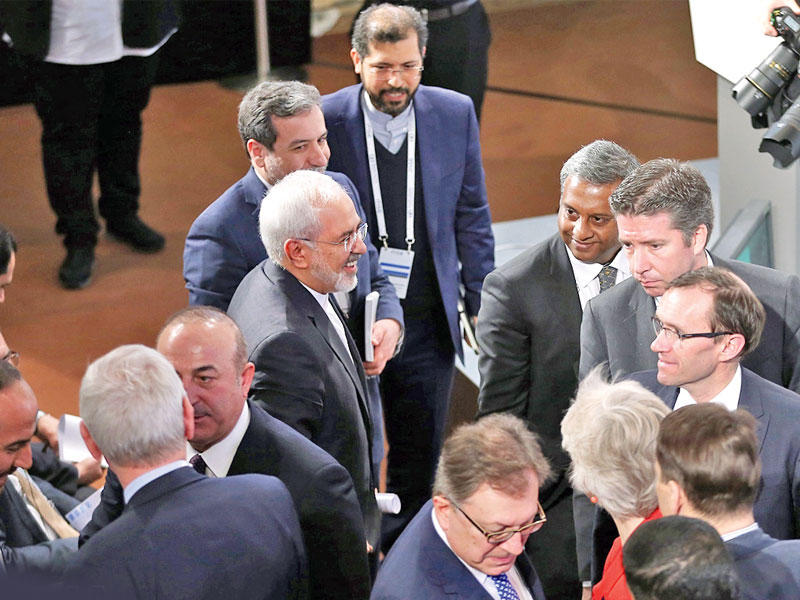 ظريف يمر بجانب كبير مفاوضي المعارضة السورية نصر الحريري (أقصى اليسار) أمس خلال مؤتمر ميونيخ (إرنا)  