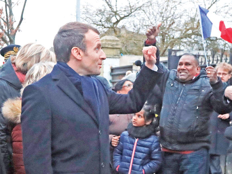 ماكرون خلال زيارته مناطق تعرضت لفيضانات قبل أيام        (أي بي أيه)