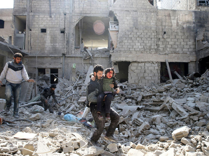 سوريون يفرون من موقع تعرض لغارة في الغوطة أمس